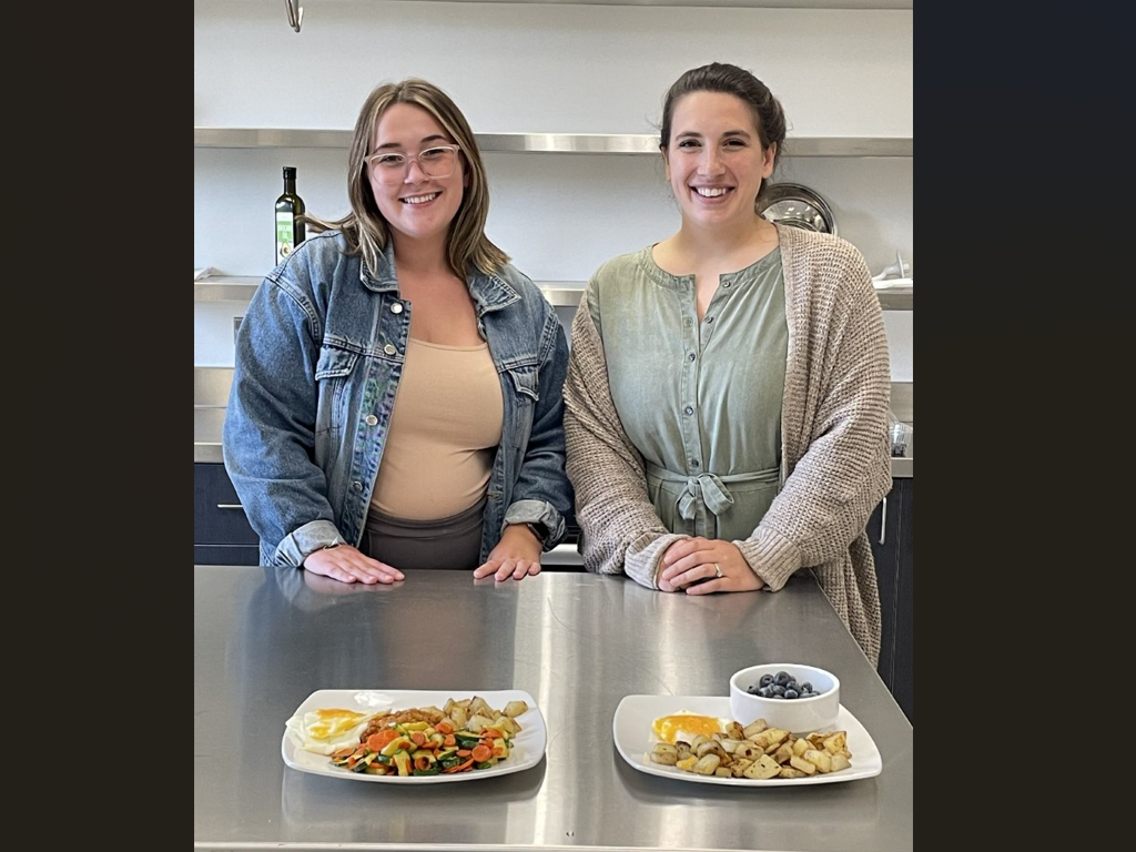 Students pose with plates of healthy food they made