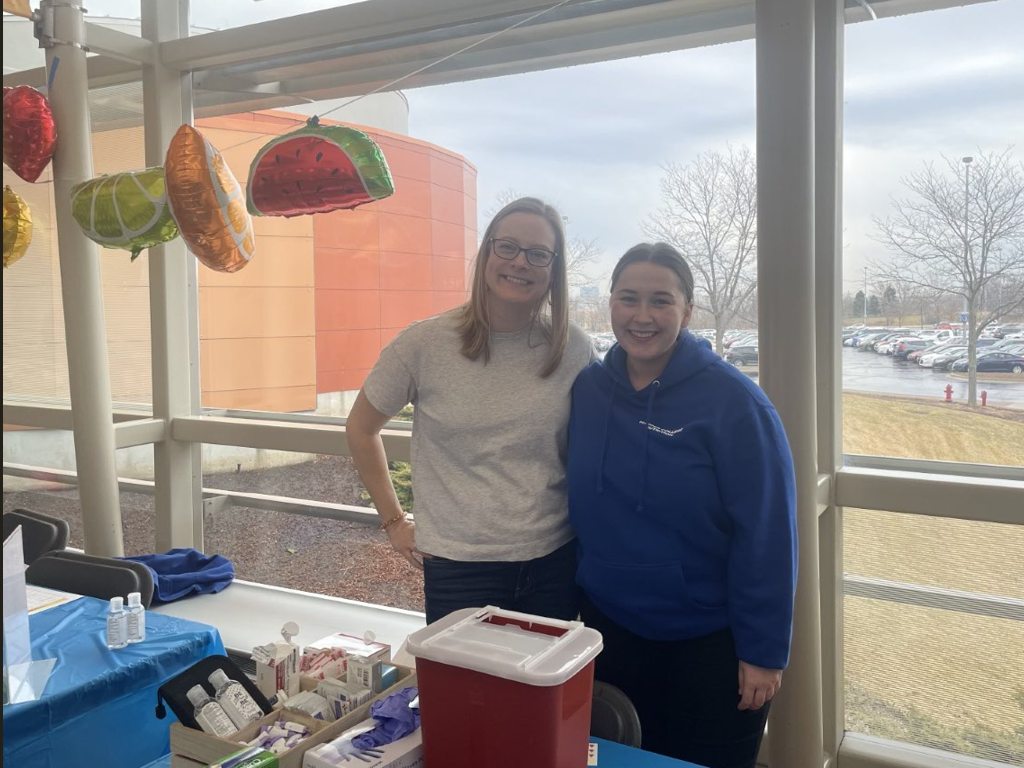 Students pose with medical supplies at a wellness event