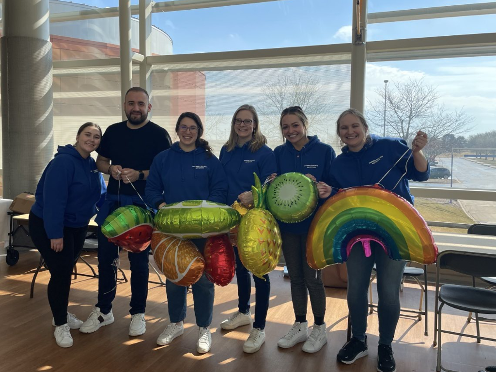 Students pose with festive food balloons at wellness event