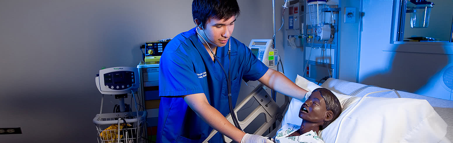 Nursing student working with patient simulator.