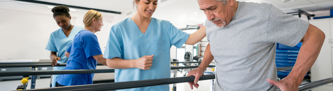 Physical therapist assistant helping man move and walk