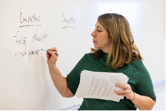 Professor writing on whiteboard