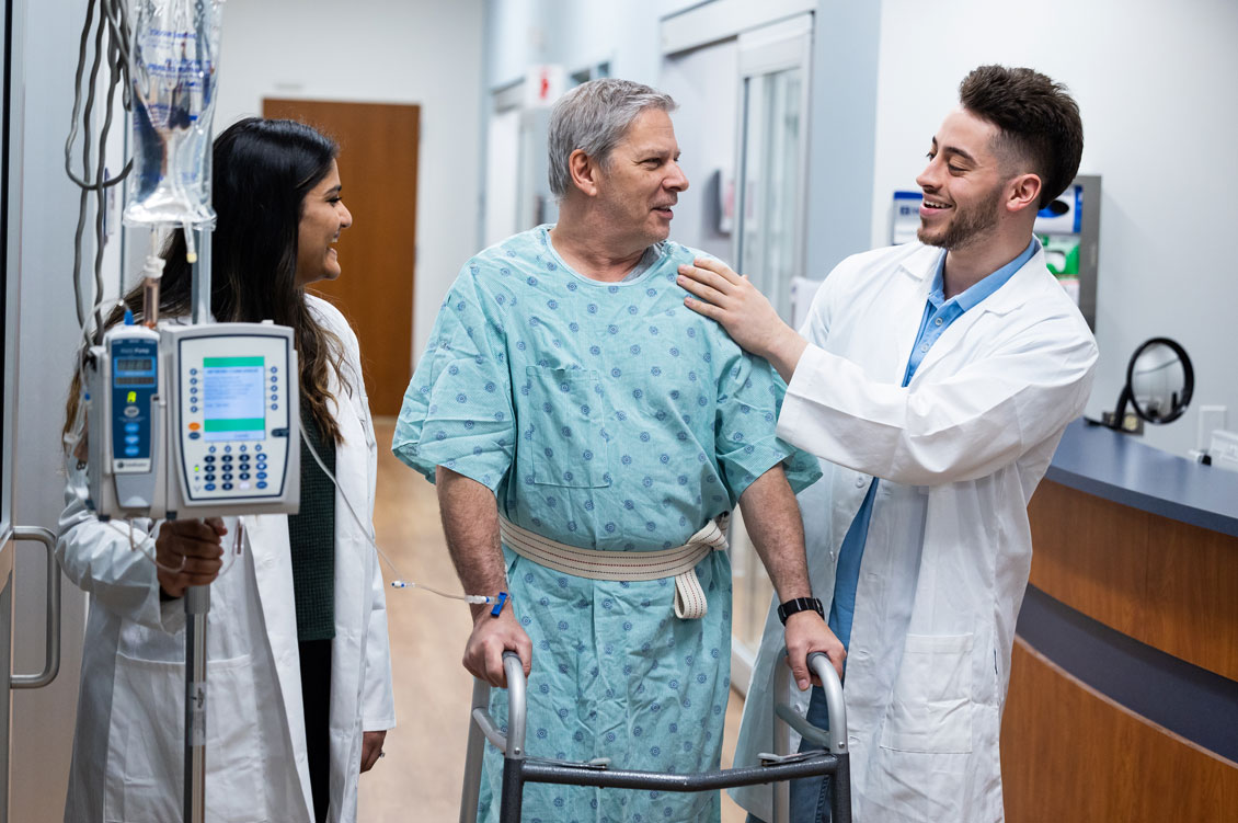 a student smiles and laughs with a simulation patient