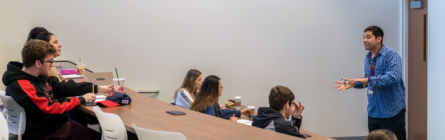 Teacher listens to question from student.