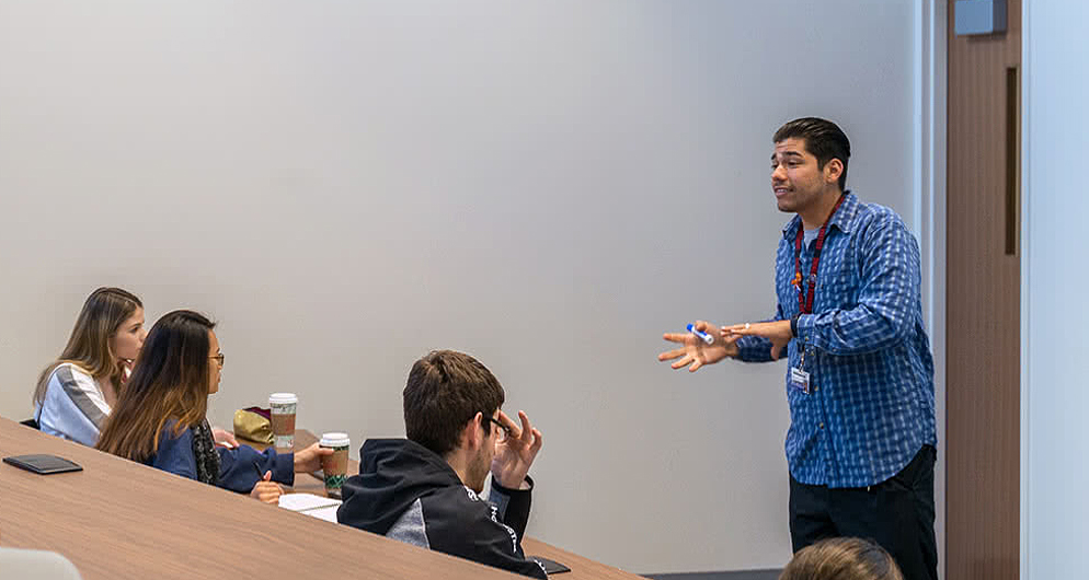 Teacher listens to question from student.