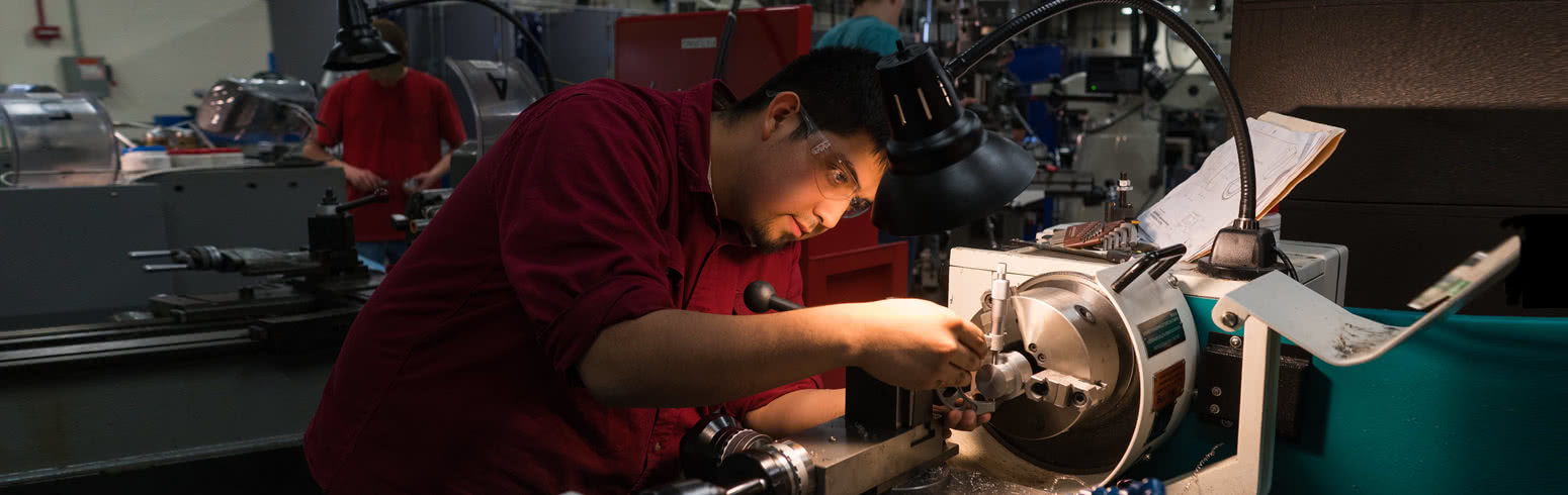 Student working with manufacturing machinery