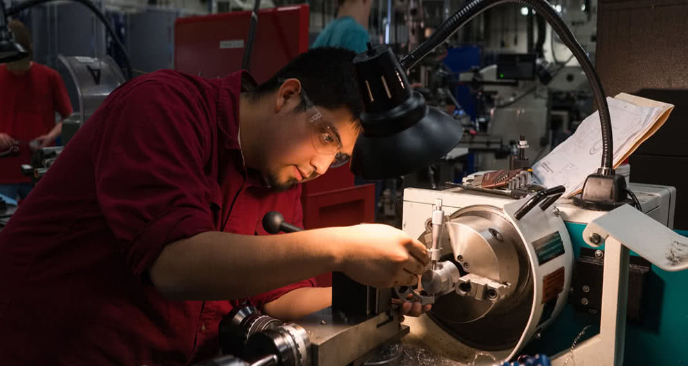 Student working with manufacturing machinery