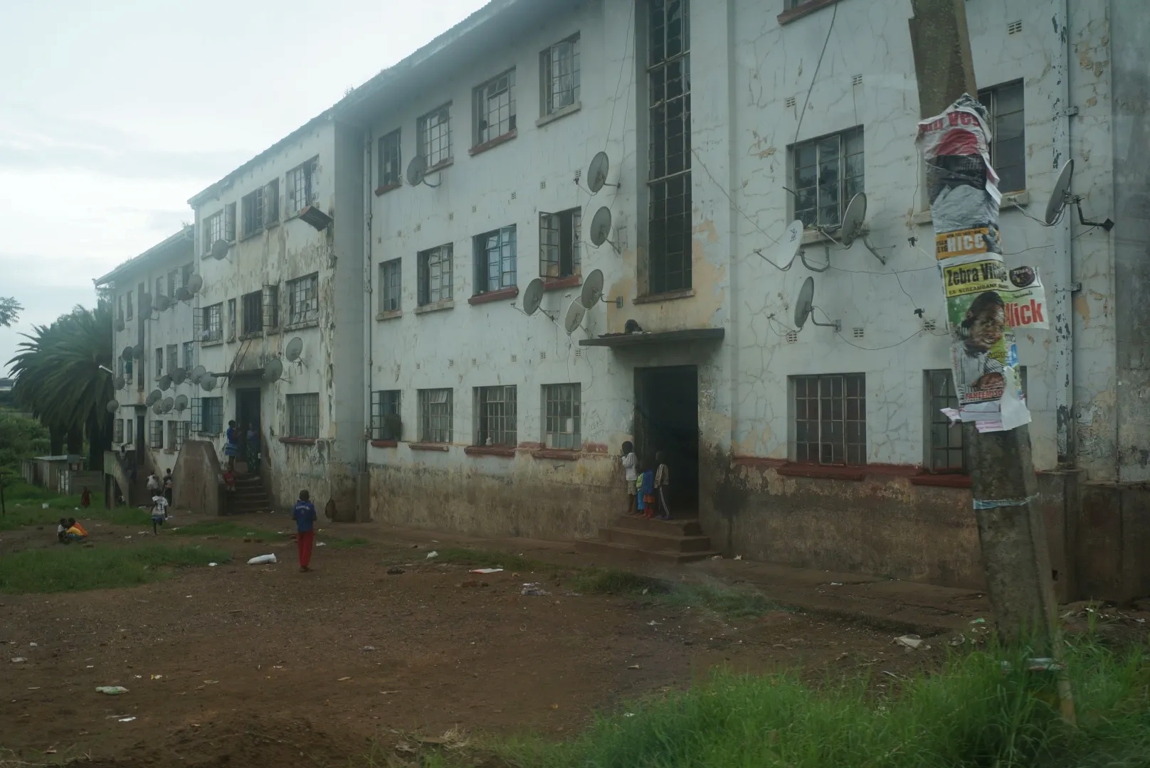 Three story building with cracks and satellite dishes outside 