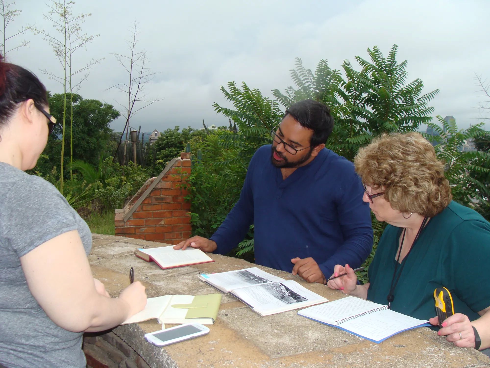 Zimbabwean guide with two Harper faculty 