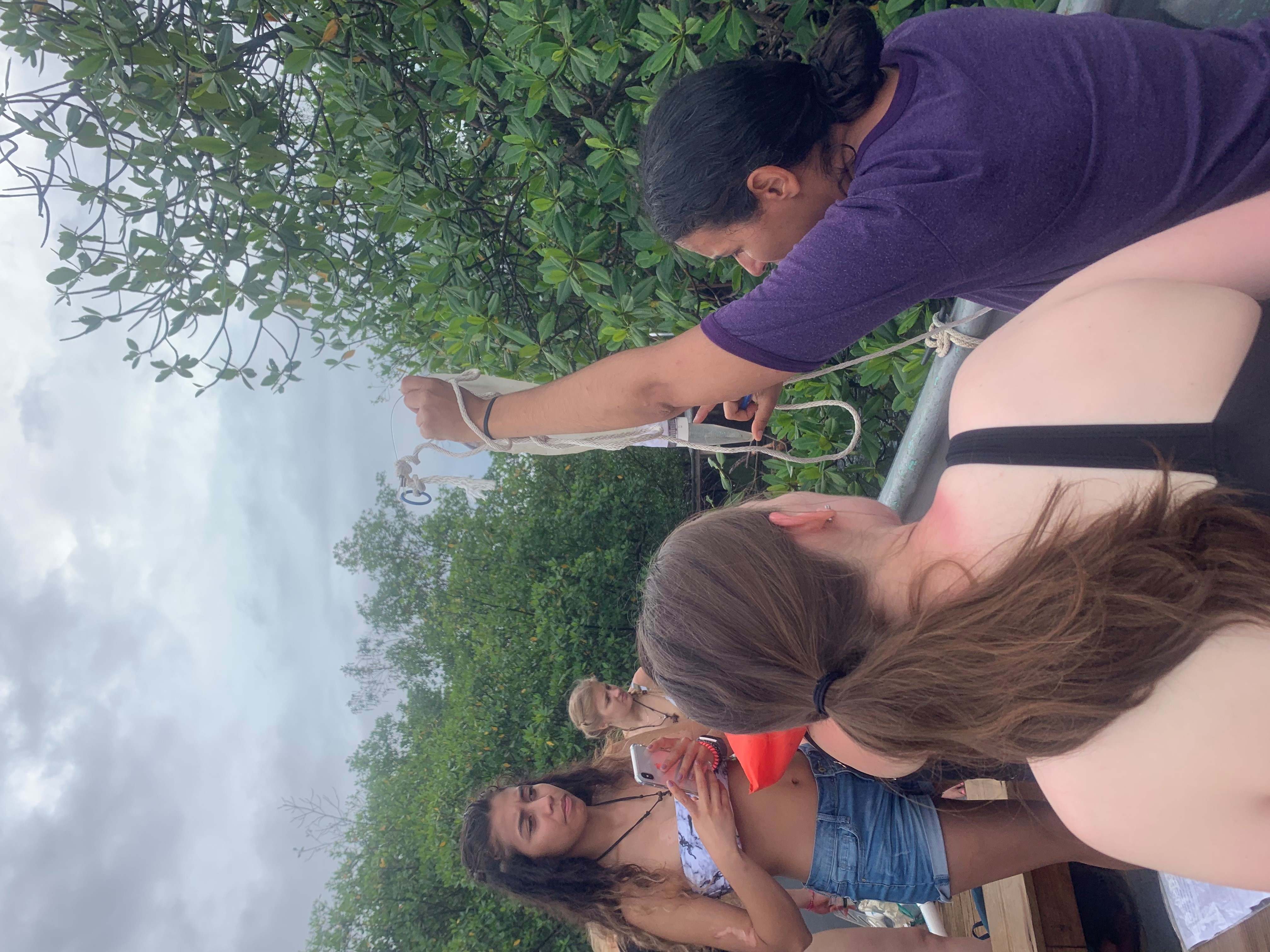 Women on a boat being taught how to use a plankton collection net
