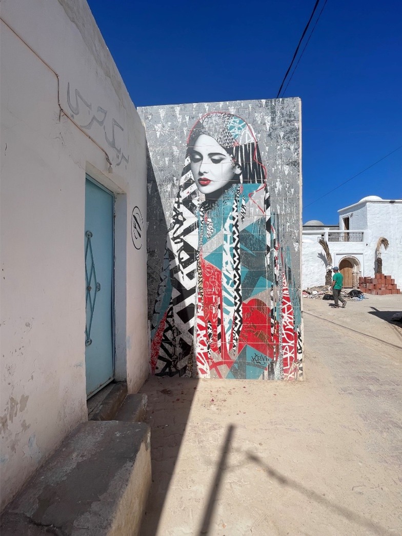 Mural of a multi-colored hijabi woman in an avant-garde style 