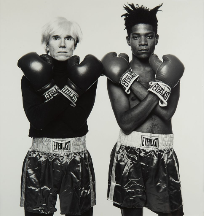 black and white photo of two boxers in trunks and gloves with arms crossed