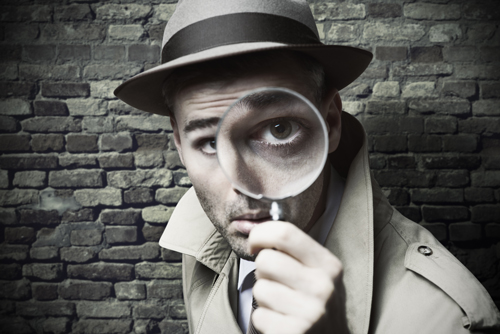 photo of a detective looking through a magnifying glass