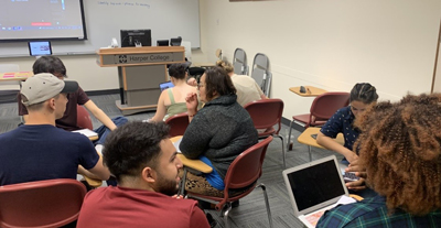 students sitting in a classroom discussing an assignment