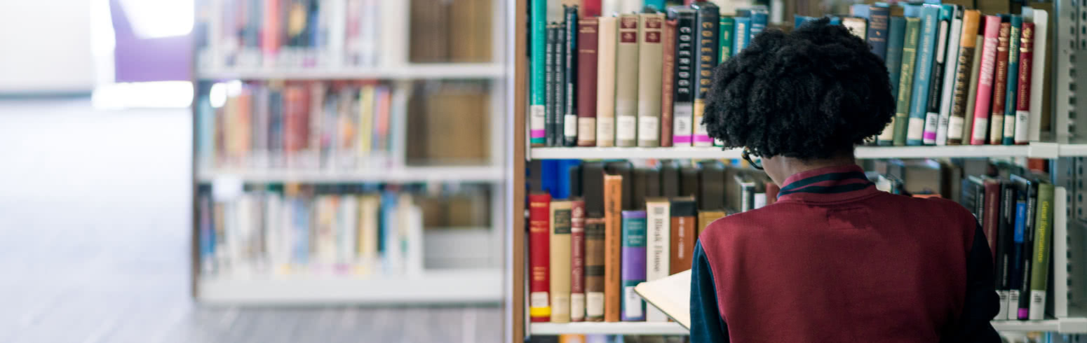 Student looking at books in library