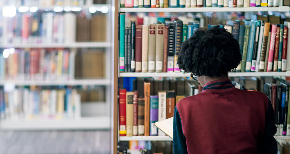 Student looking at books in library