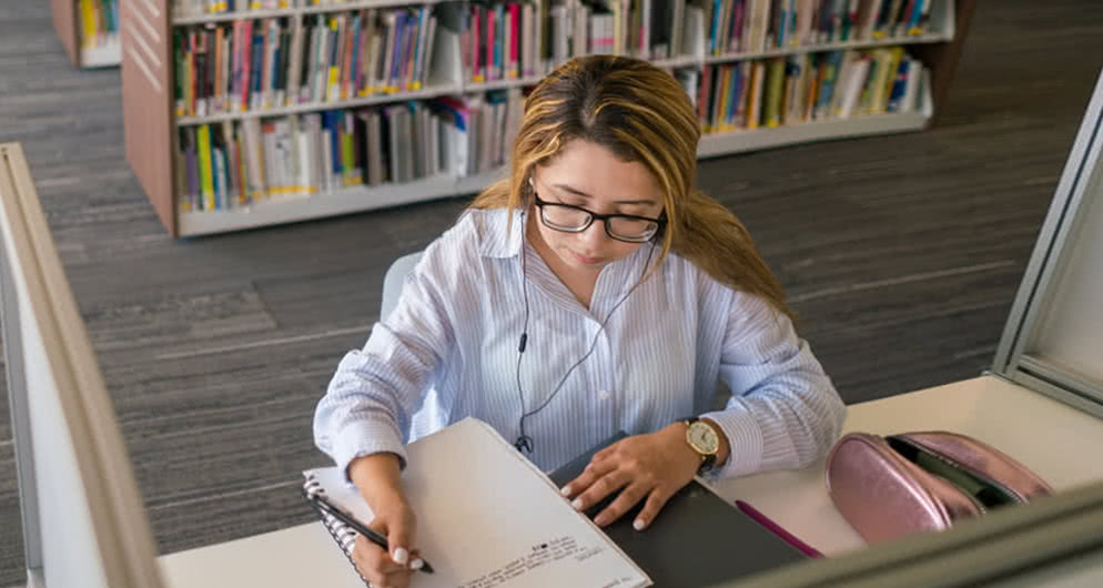 Student studies in the library photo.