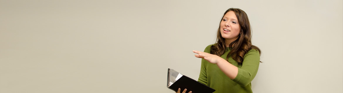 Student makes a speech on stage holding a book