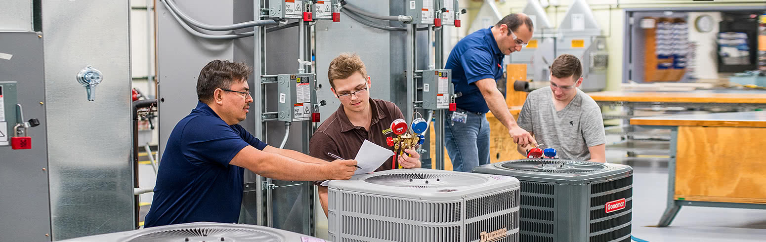Students in the HVAC school working on repairing air conditioning units with the help of Harper College professors on campus in the Chicago suburbs.