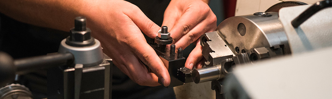 Hands working with steel machinery