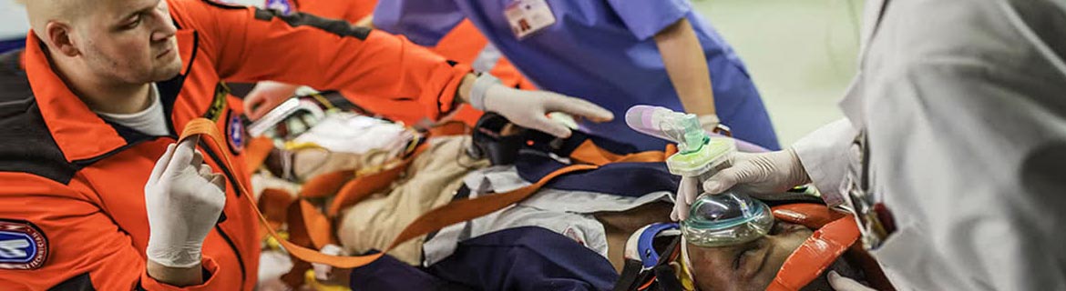 Man addressing medical emergency and another man on a stretcher