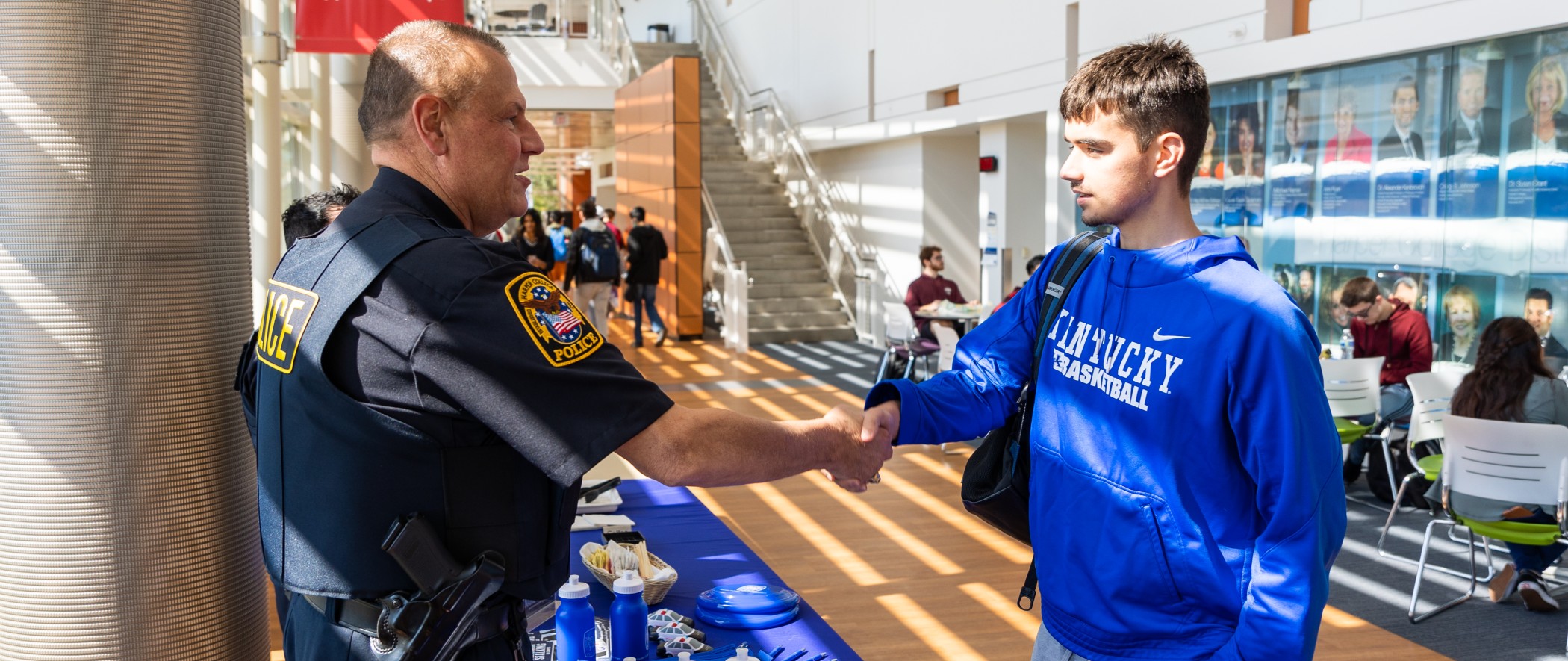 Harper College police officer shaking hands with a student in the Law Enforcement and Justice Administration program on the Harper campus in Palatine, Illinois.