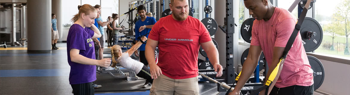 People at the gym working on personal fitness equipment