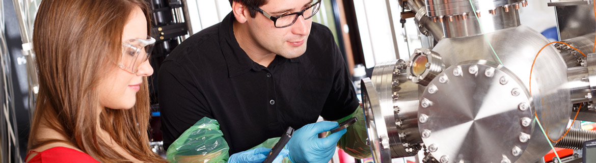 Two people working on an experiment with a physics context in a lab