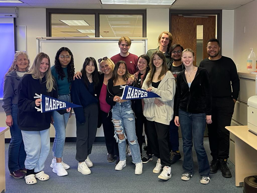 Geography program faculty and students pose for a photo in a classroom on the Harper College campus in the Chicago suburbs.
