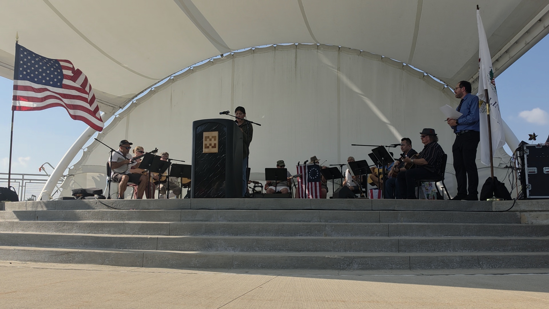 A student speaker stands at a podium on an outdoor stage at the Constitution Day Event at Harper College