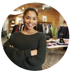 Woman, smiling, with clothing racks in background