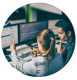 Employees look at computer screen