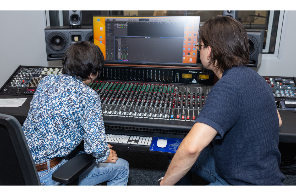 Harper music faculty member Edward Hamel assists a student with recording equipment