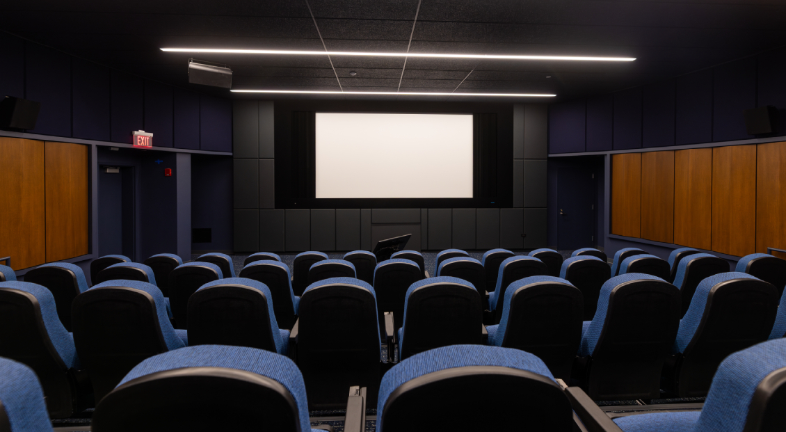 The Movie Screening Room/Film Lab at Harper College, viewed from directly behind the empty seats that face the large projector screen