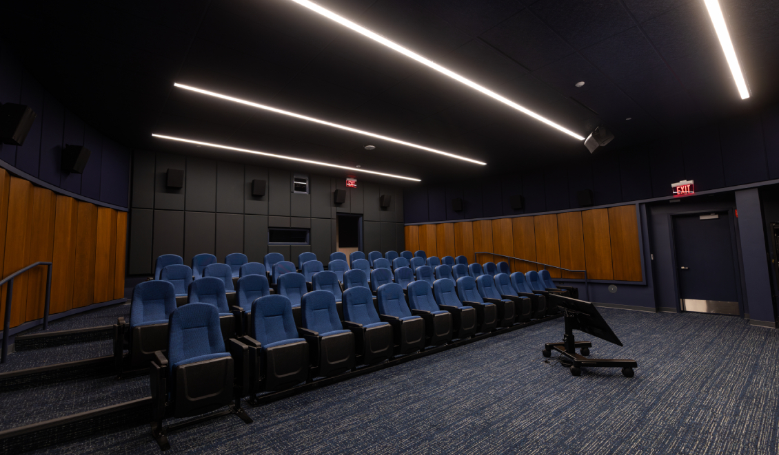 The empty rows of seats in the Movie Screening room viewed from the corner of the room, showing the many people it can accommodate