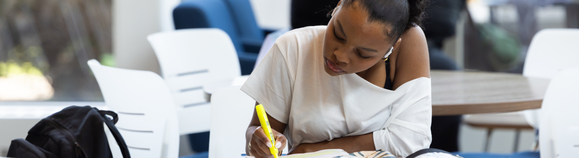 a harper college student highlighting a passage from her study material