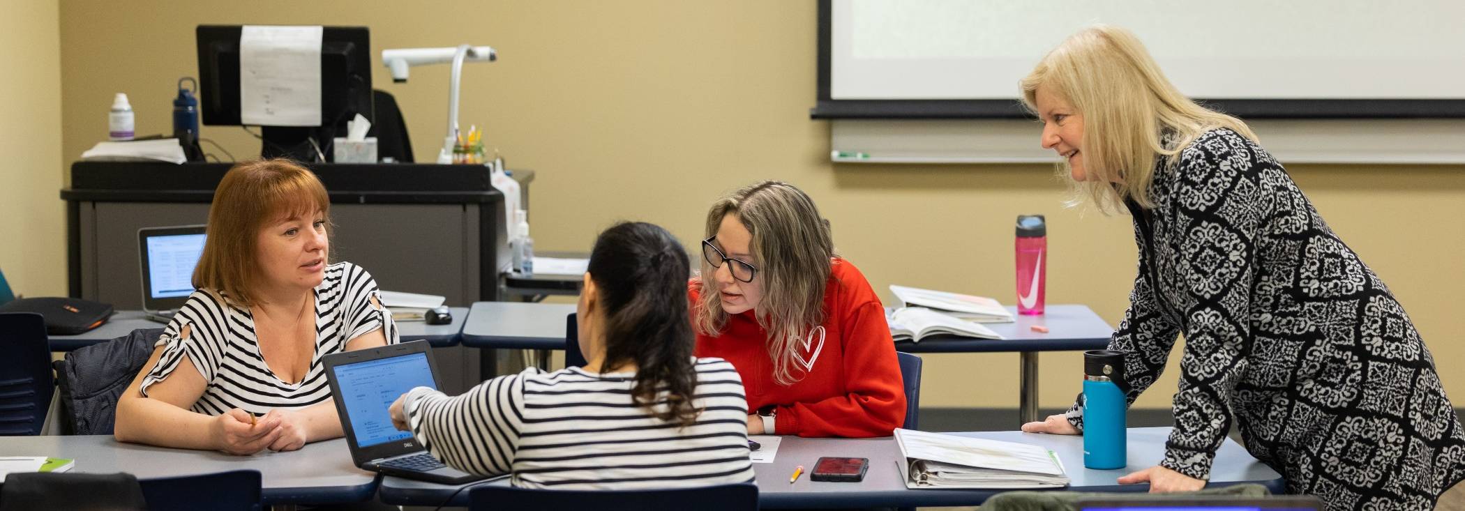 Adult education students speaking with professor