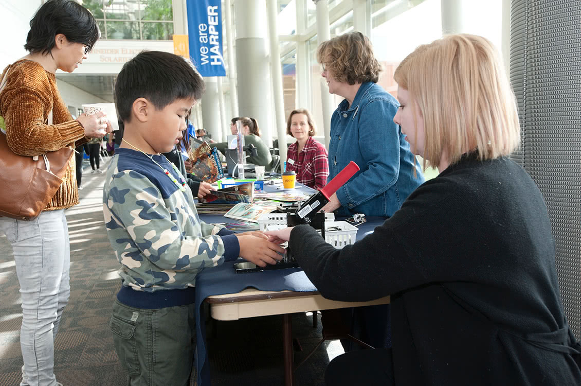 An instructor showing a child a microscope