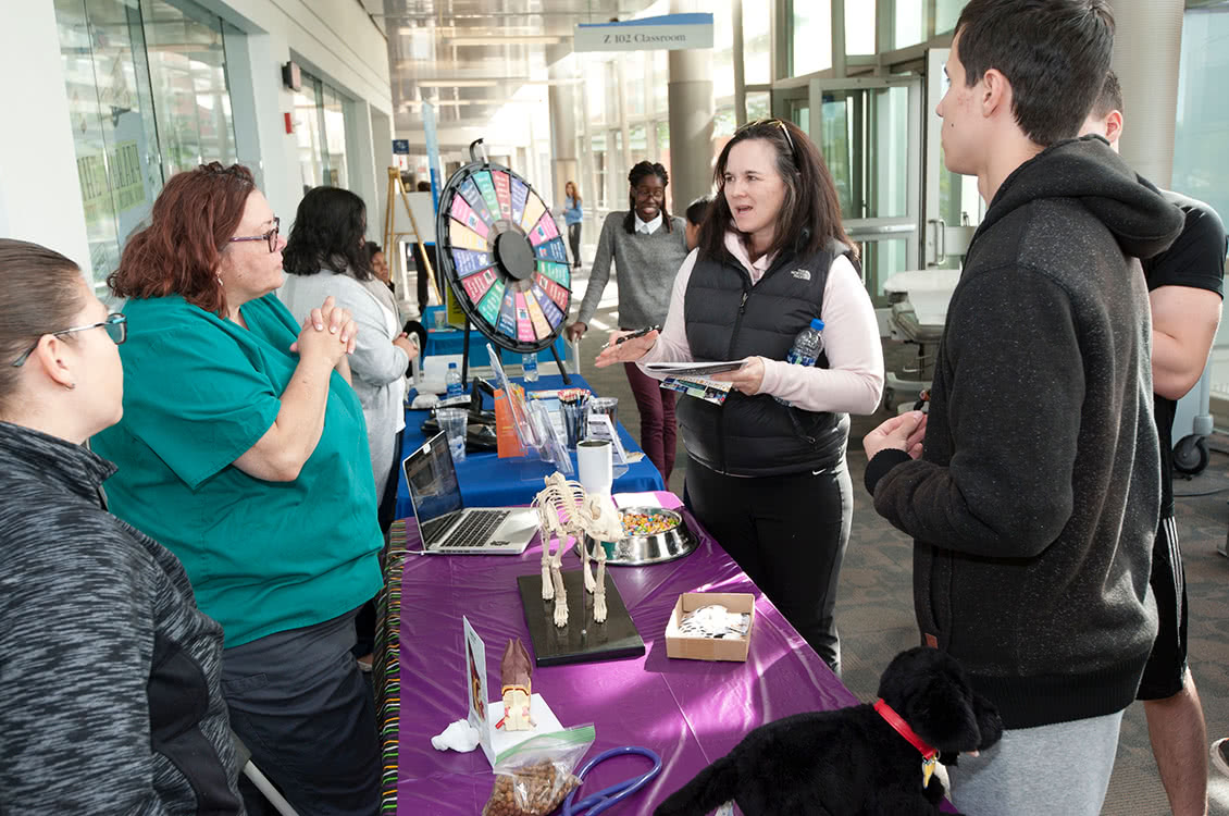 A group of people talking around an experience a booth