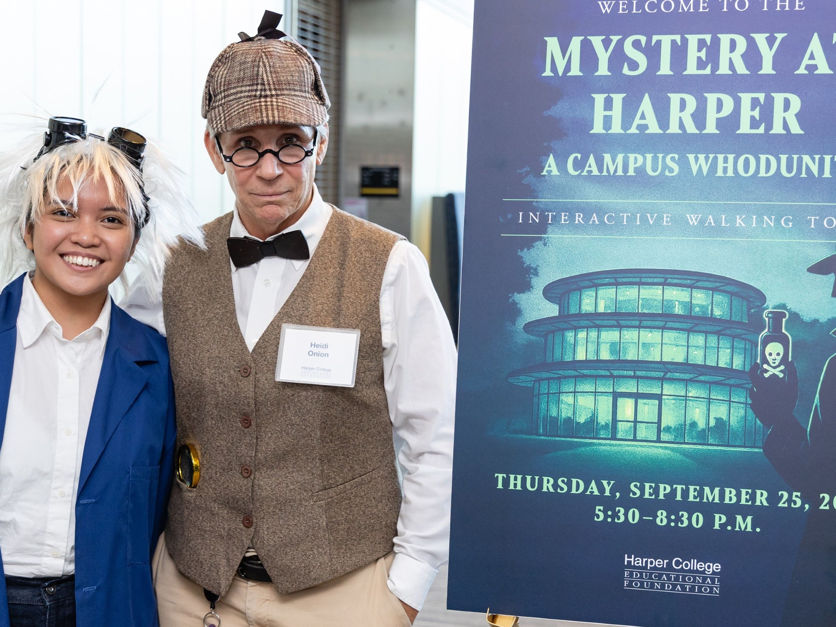 Members of the law enforcement and justice team dressed as Sherlock Holmes and Watson next to a sign for the Mystery at Harper event