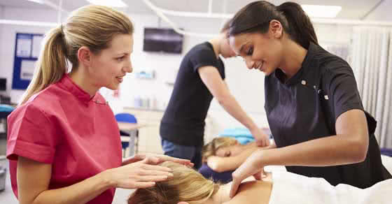 Massage therapy instructor teaching student.