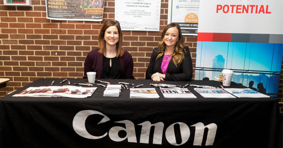 Two Canon representatives sitting at a booth at a past Graphic Arts Print Expo