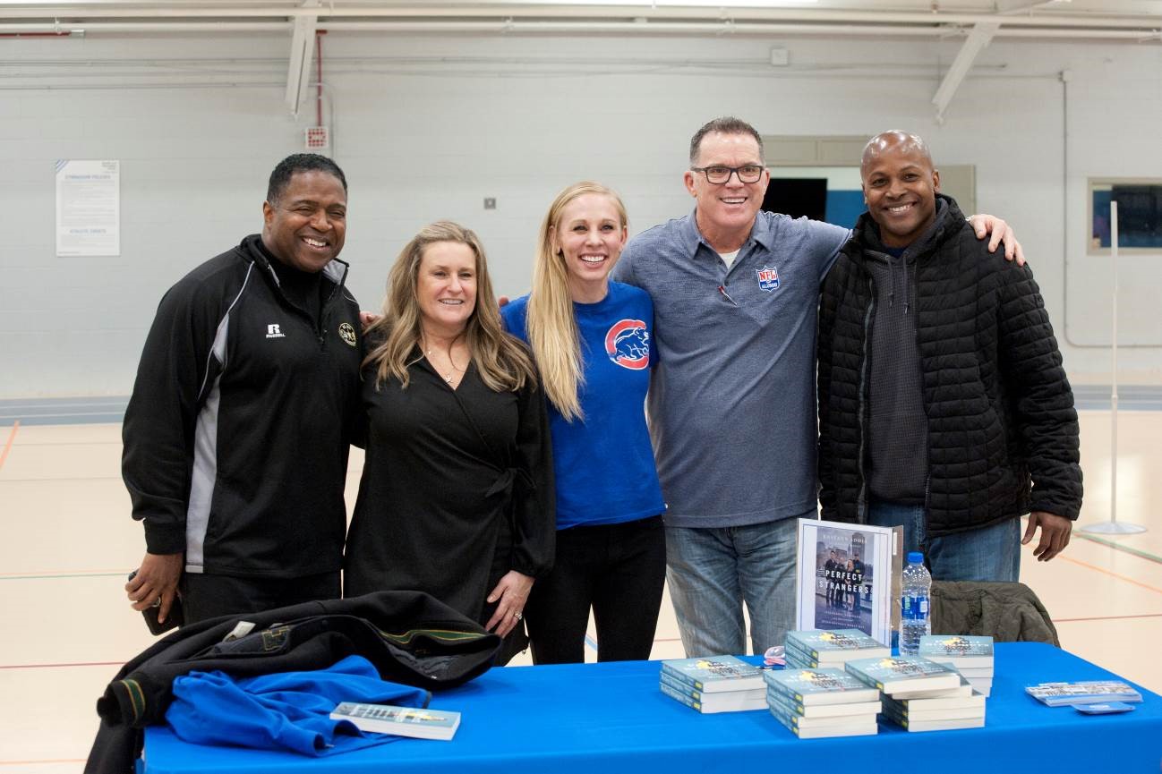 Photo of participants at Adaptive Sports Day smiling with their arms around one another. 