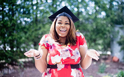 Student in graduation cap, shrugging shoulders