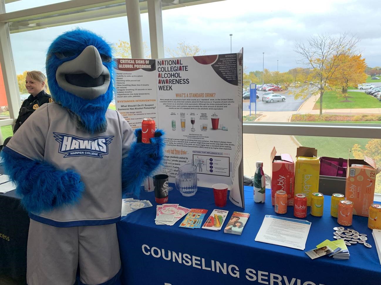 Photo of Harper Hawk holding a can of bubbly water. 