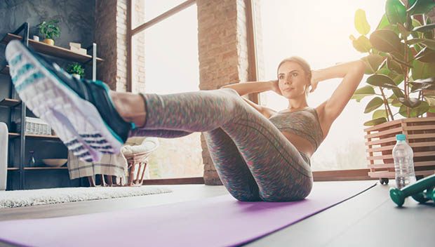 A woman exercises at home.