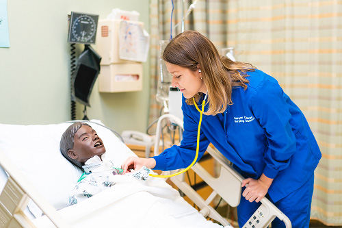 Nursing student works with patient simulator dummy
