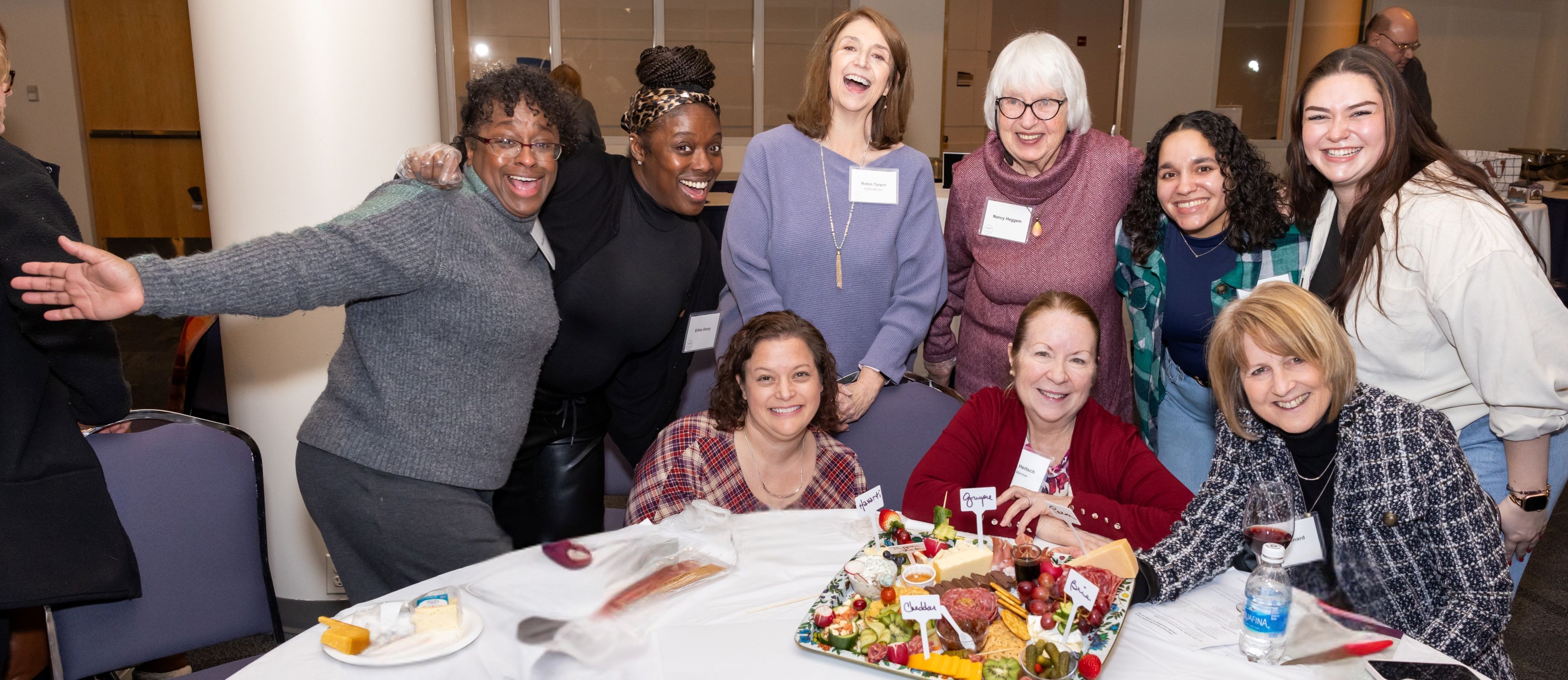 Guests stand proudly around a charcuterie board they created at a HOPE Giving Circle event.