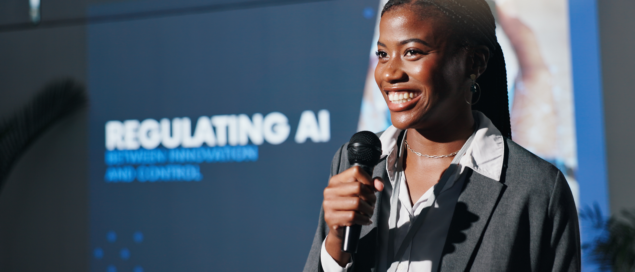 Student speaking into a microphone during a presentation on regulating artificial intelligence.