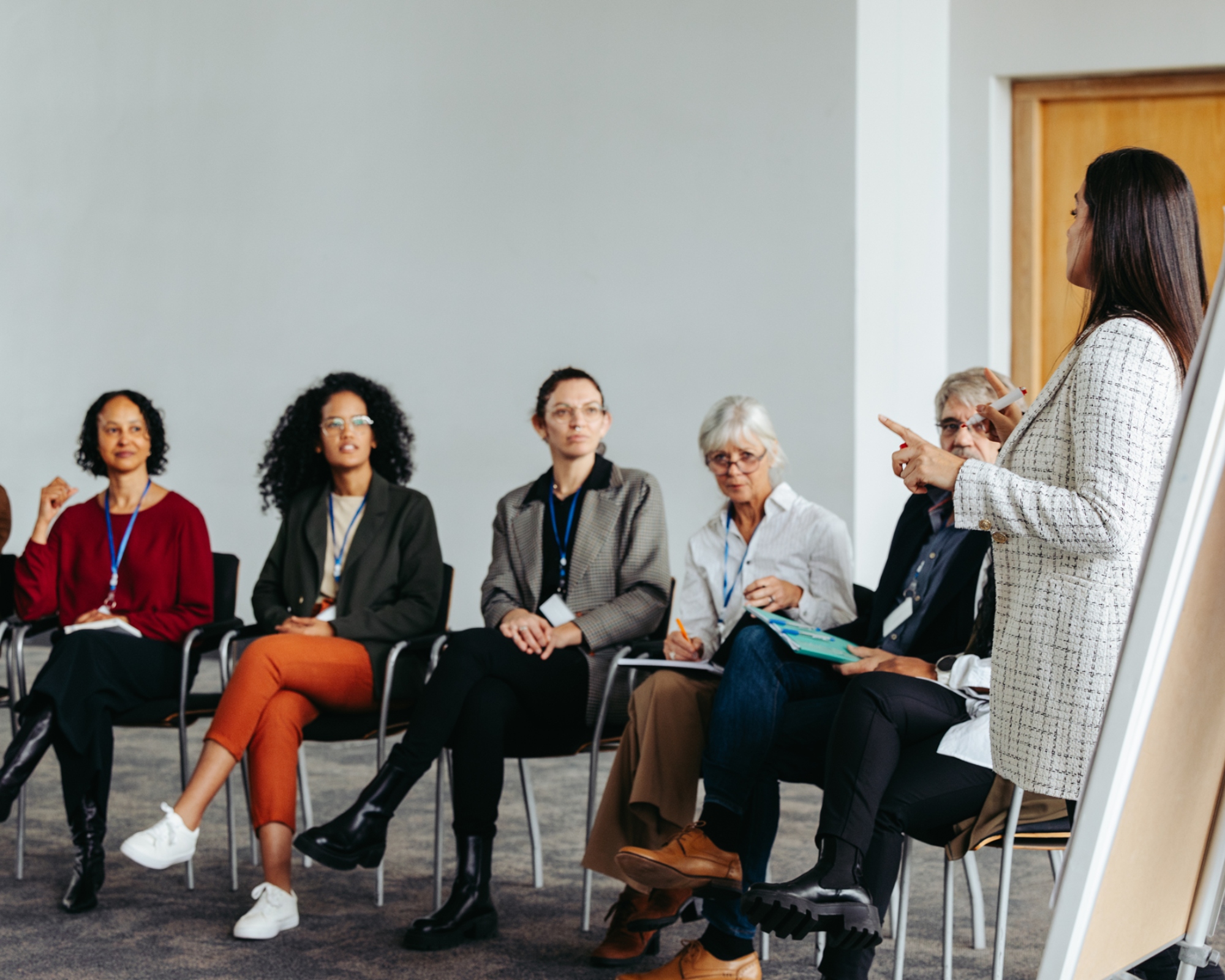 Cybersecurity professionals sit in a meeting where they generate new ideas, led by their coordinator.
